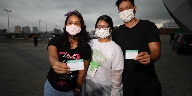 Técnica de enfermagem vacina marido e irmã na abertura do mutirão Vacina Amazonas